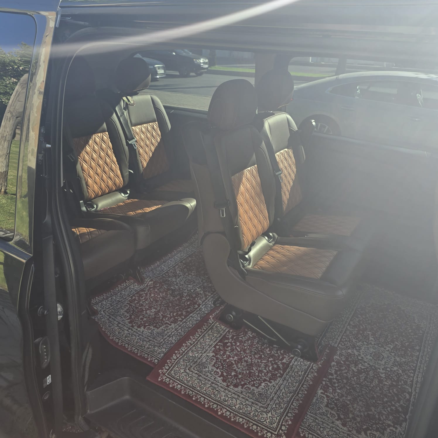 Tan quilted leather seats and red patterned carpets inside our Mercedes V-Class