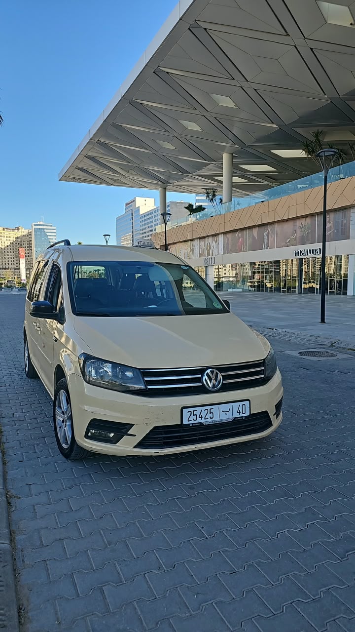 Cream Volkswagen Caddy parked outside a modern building in Tangier